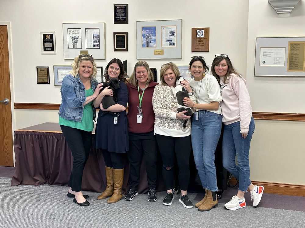 board office staff with puppies